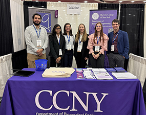 group of people in front of city college of new york sign