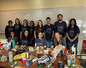 group of people in blue tee shirts with an array of snacks in front of them