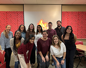 group of people posing in front of a red wall