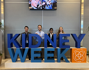 group of people in front of kidney week sign