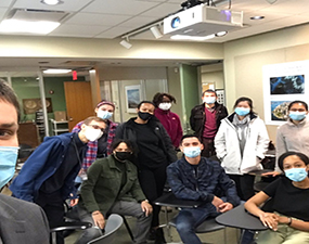 group of people wearing masks, the person closest is taking a selfie
