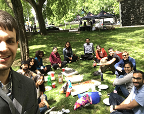 group of people in a park, the one closest is taking a selfie