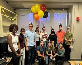 group of people wearing party hats and balloons in the background