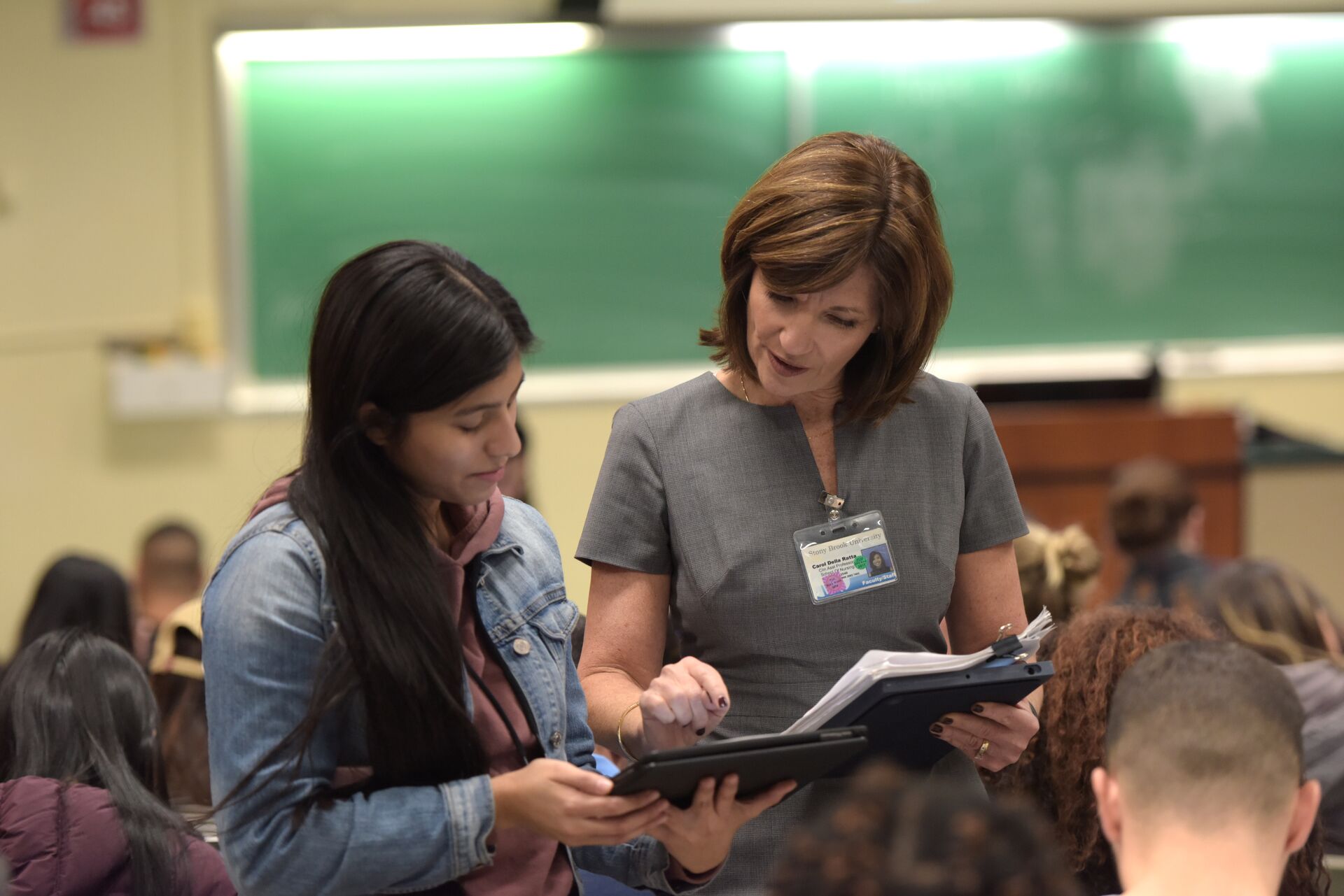 teacher with student in classroom