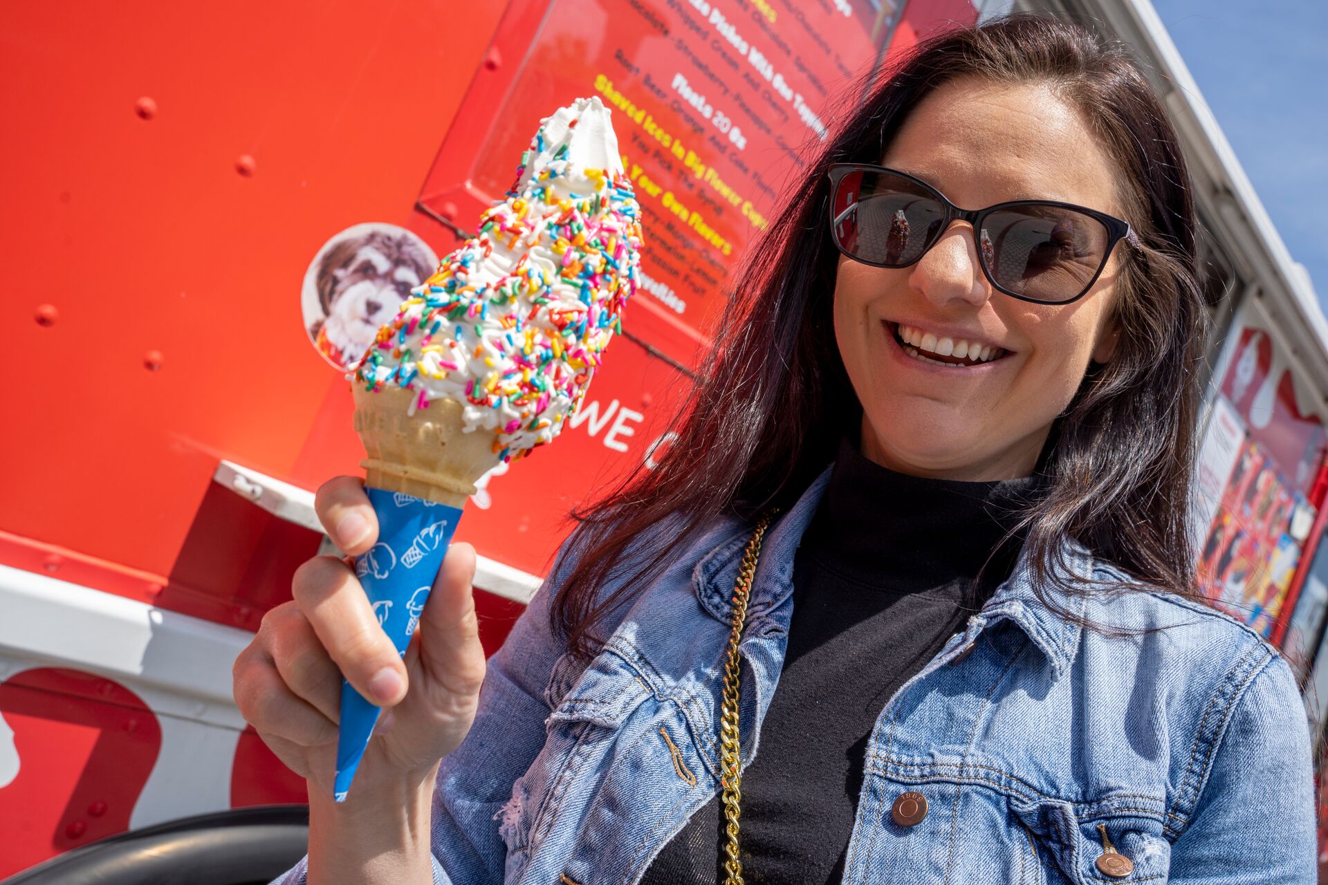Student eating a vanilla ice cream cone with colored sprinkles.