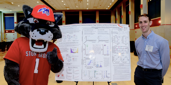 MSTP program student and Wolfie mascot with poster presentation