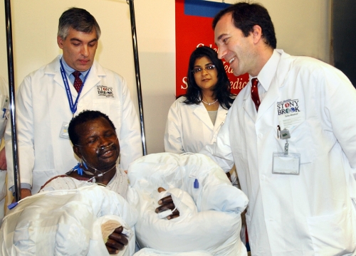 Dr. Alexander Dagum (right) with patient Arsenio Matias, whose hands were successfully reattached by Dr. Dagum and his team. Standing behind them are anesthesiologists Dr. Kenneth Rosenfeld (left) and Dr. Neera Tewari. an image is here